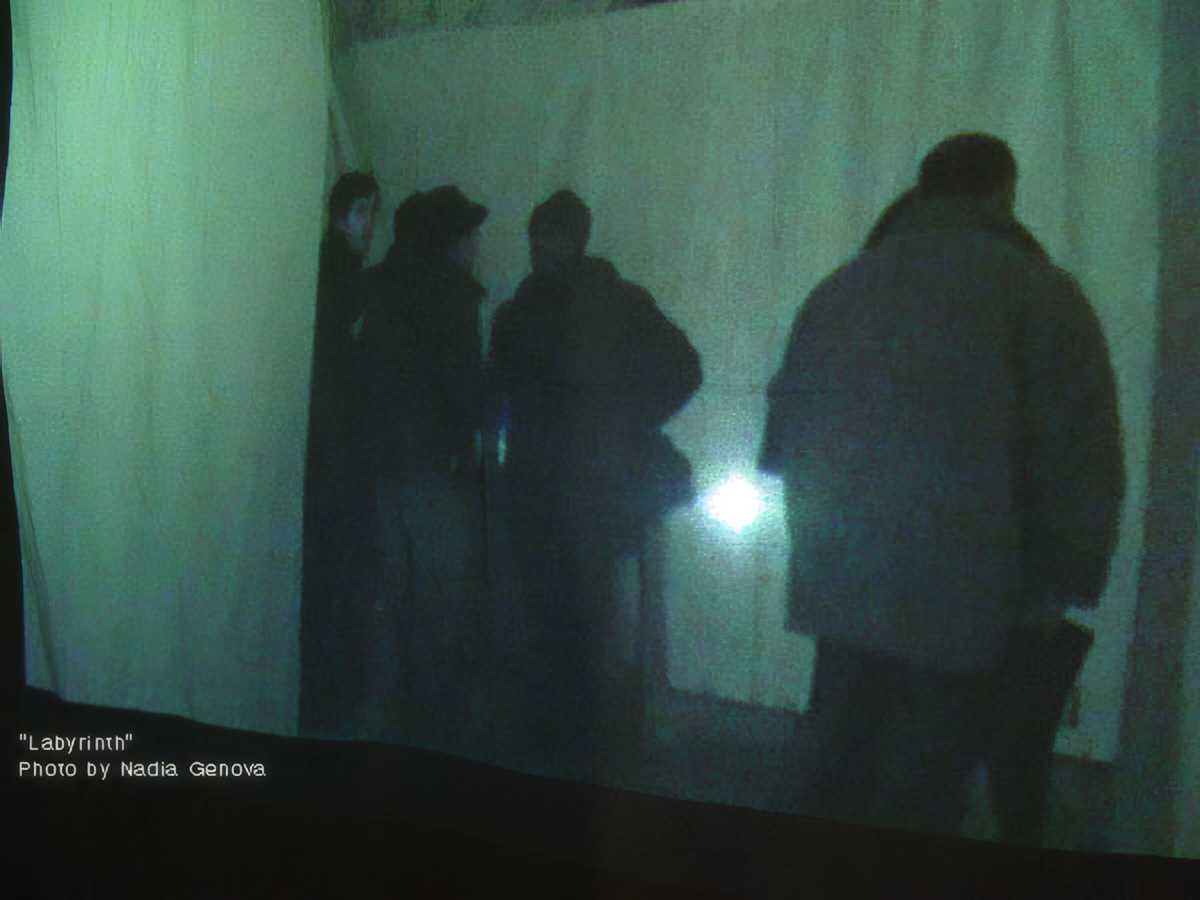 Visitors interacting with a green multimedia light projection inside the Labyrinth art installation by Hristo Yordanov and Angelina Galanska in Plovdiv.