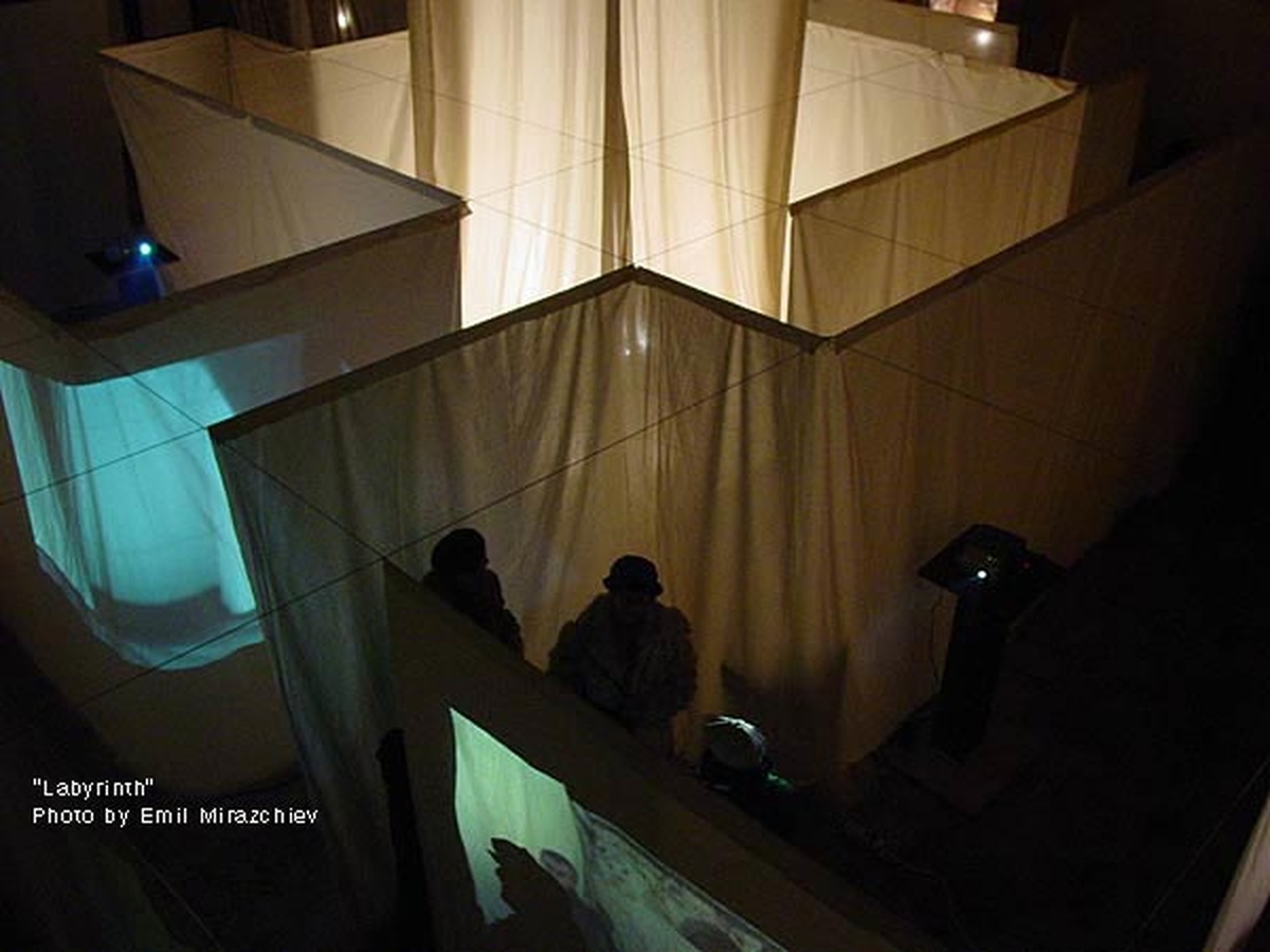 Exhibition visitors walking through the illuminated fabric pathways of the interactive Labyrinth installation.